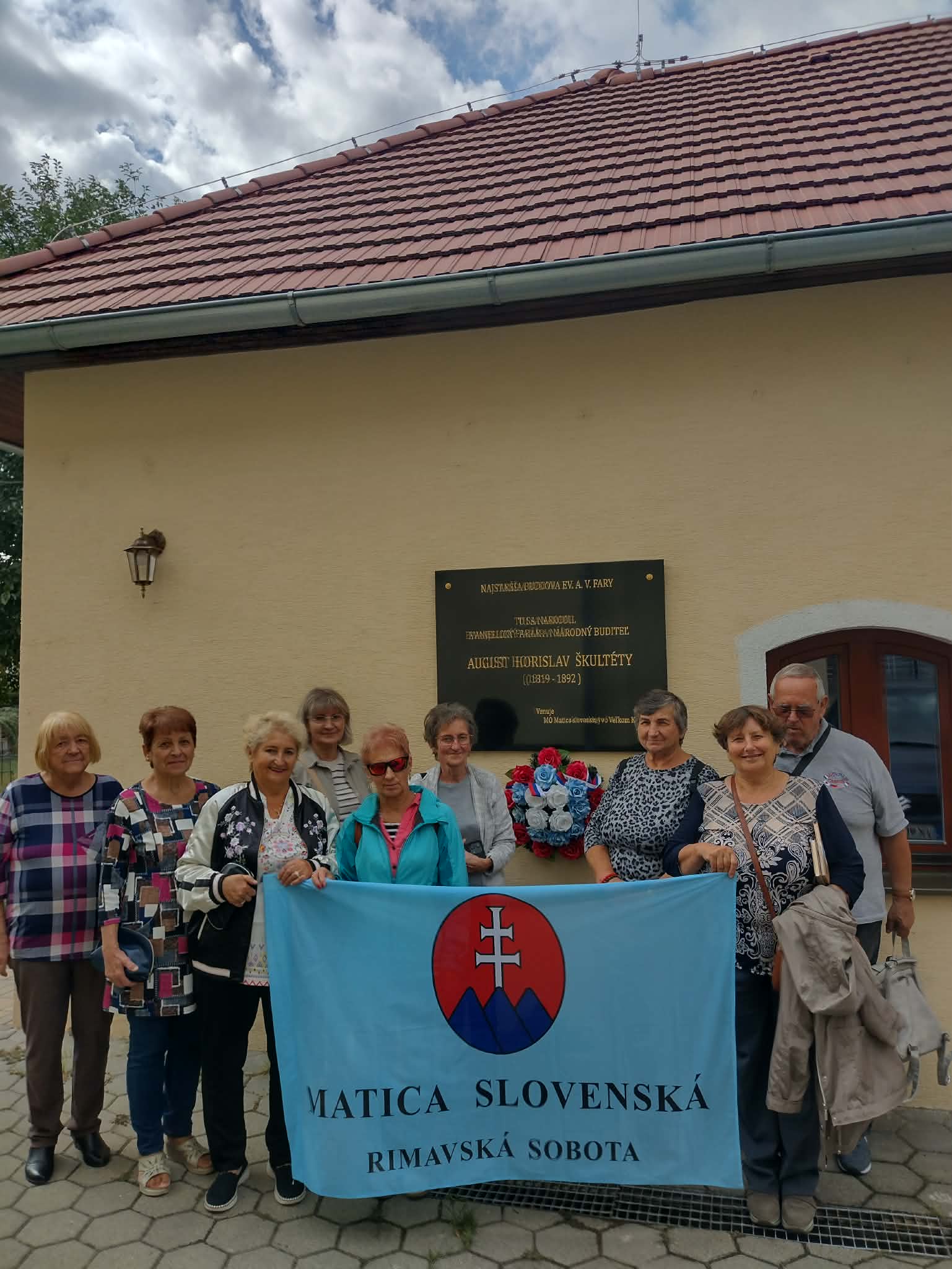 Skupina ľudí  s matičnou zástavou pred rodným domom Škultétyho