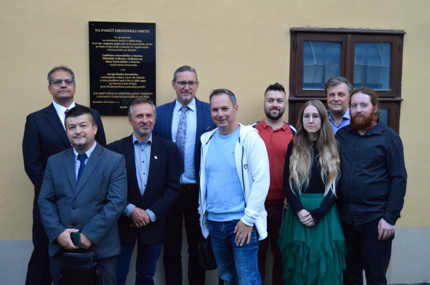 Skupina matičiarov pred pamätnou tabuľou